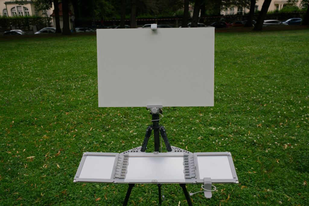 Easel with blank canvas on grass