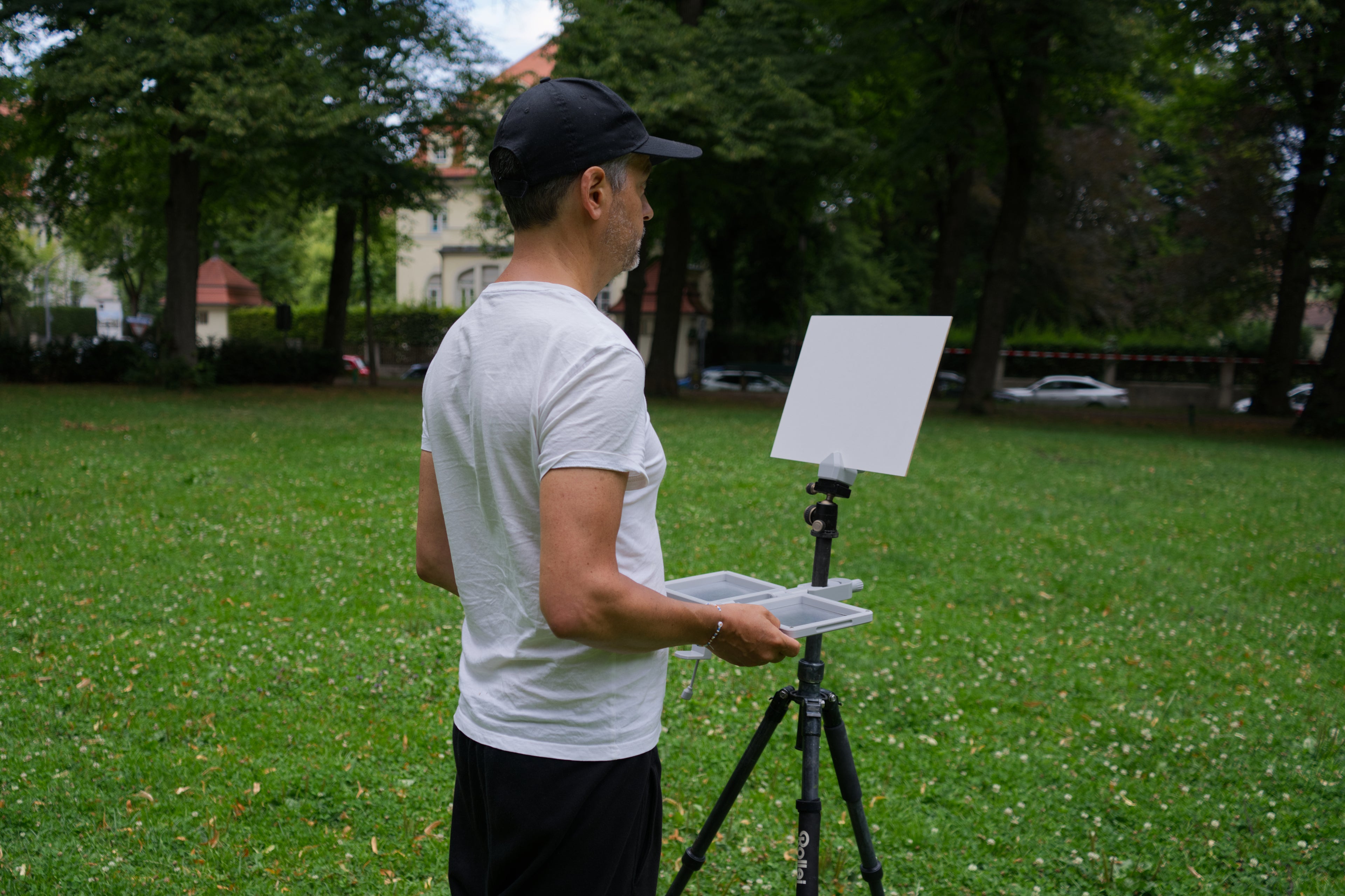 Person with a tablet on a tripod in a park setting